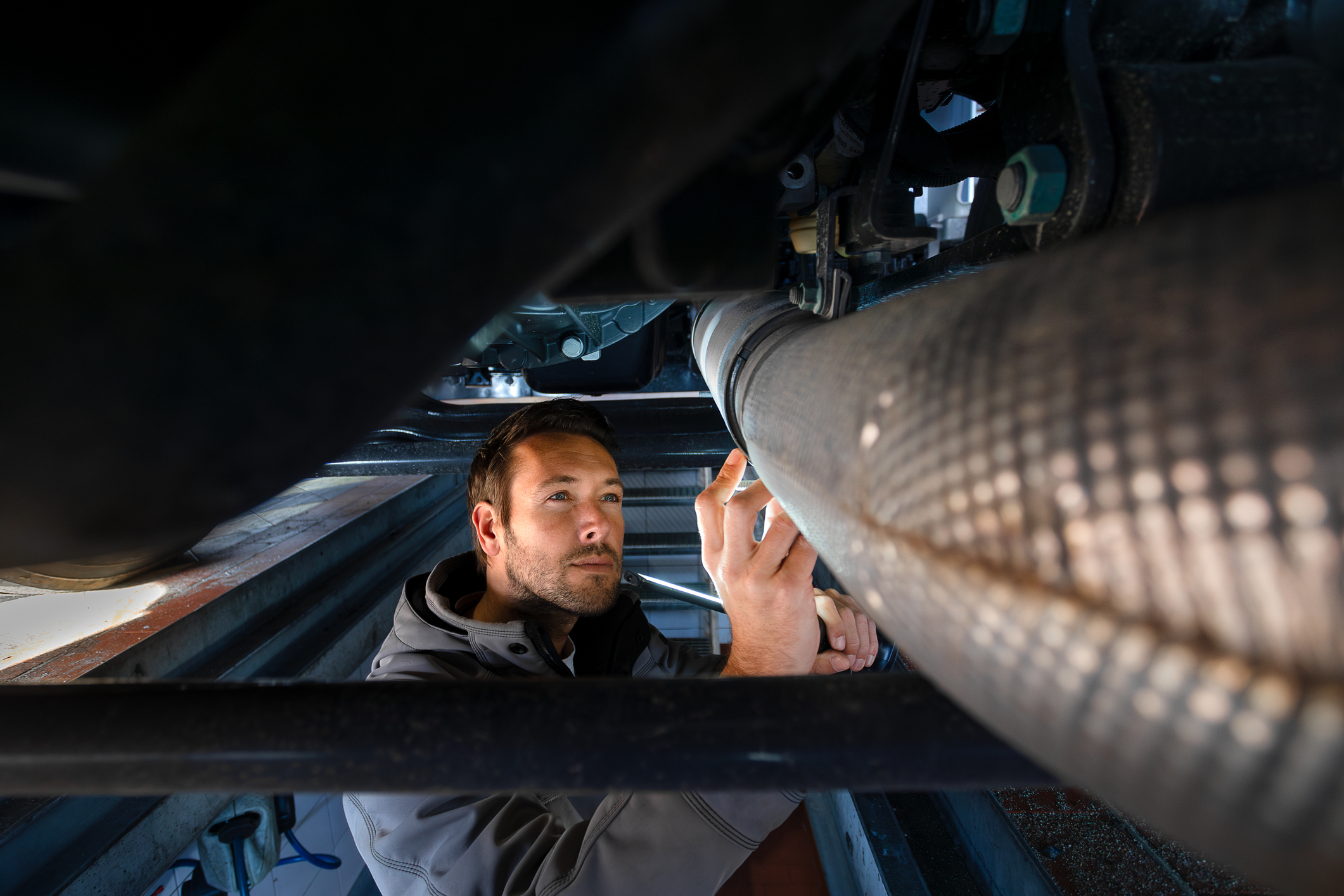 Truck mechanic checking exhaust pipe