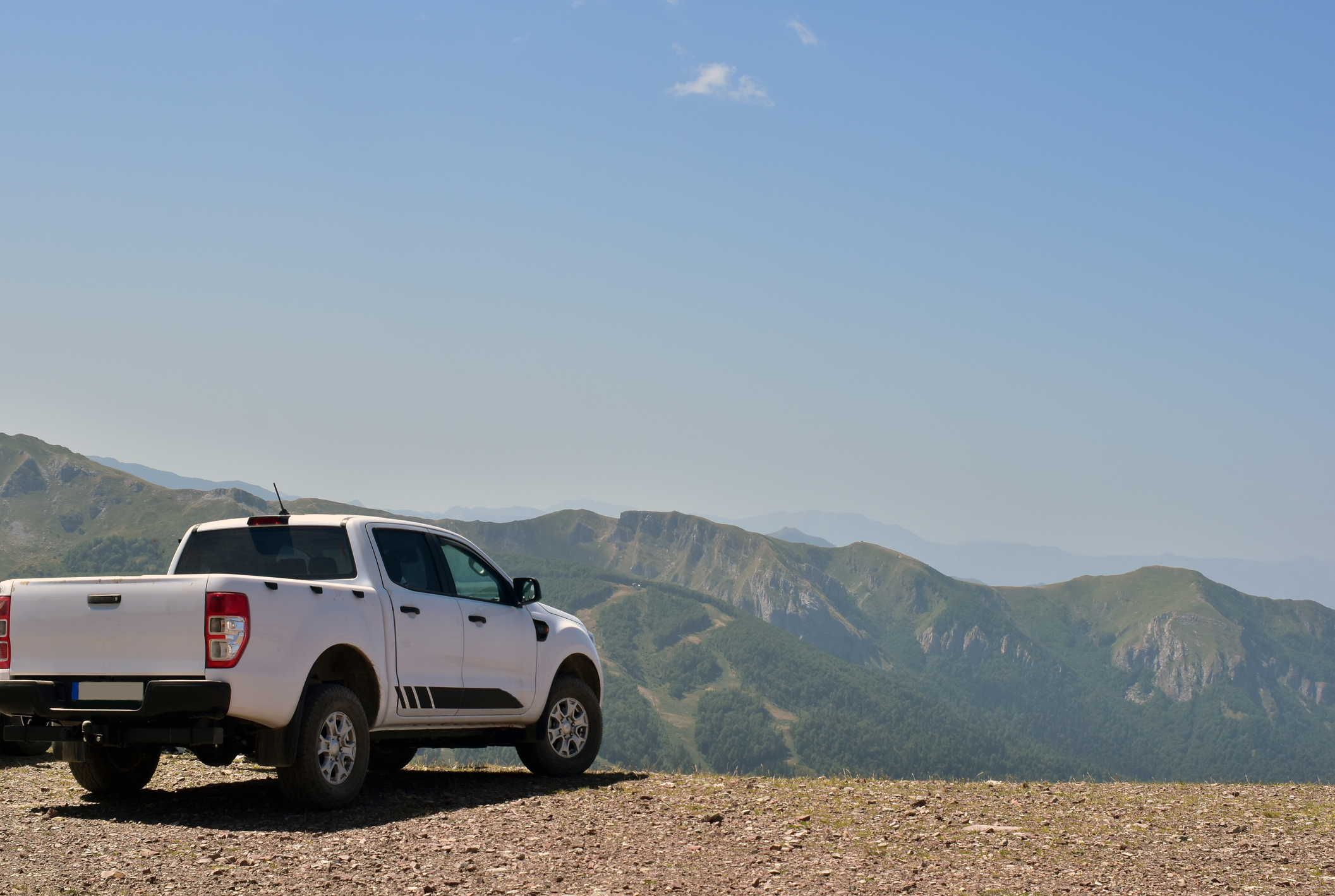 Offroad pickup truck on top of the mountain. Sunny day in the mountains. Exploring the beauty in nature with vehicles of terrain