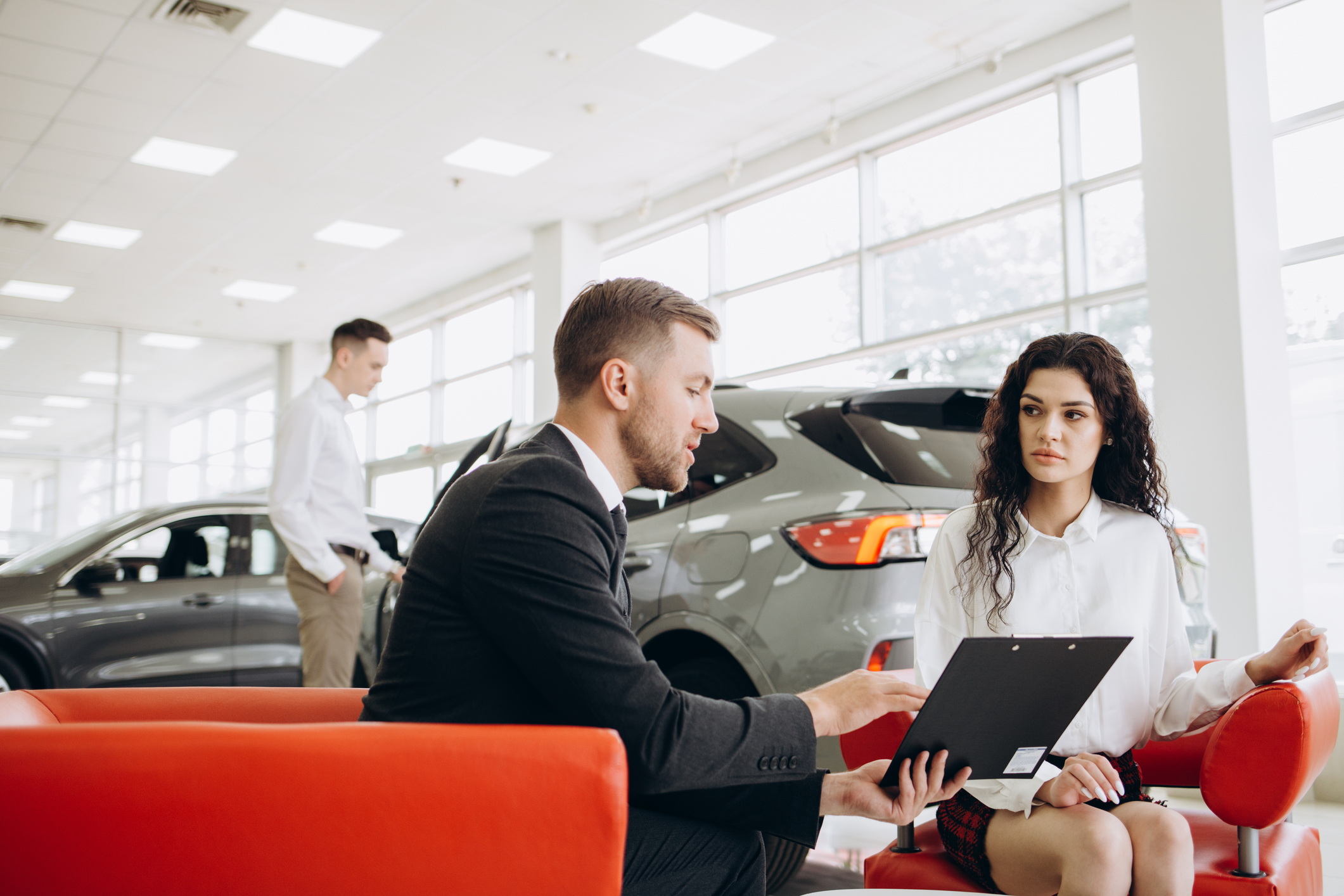 Happy couple signs a contract for the purchase of a car salon