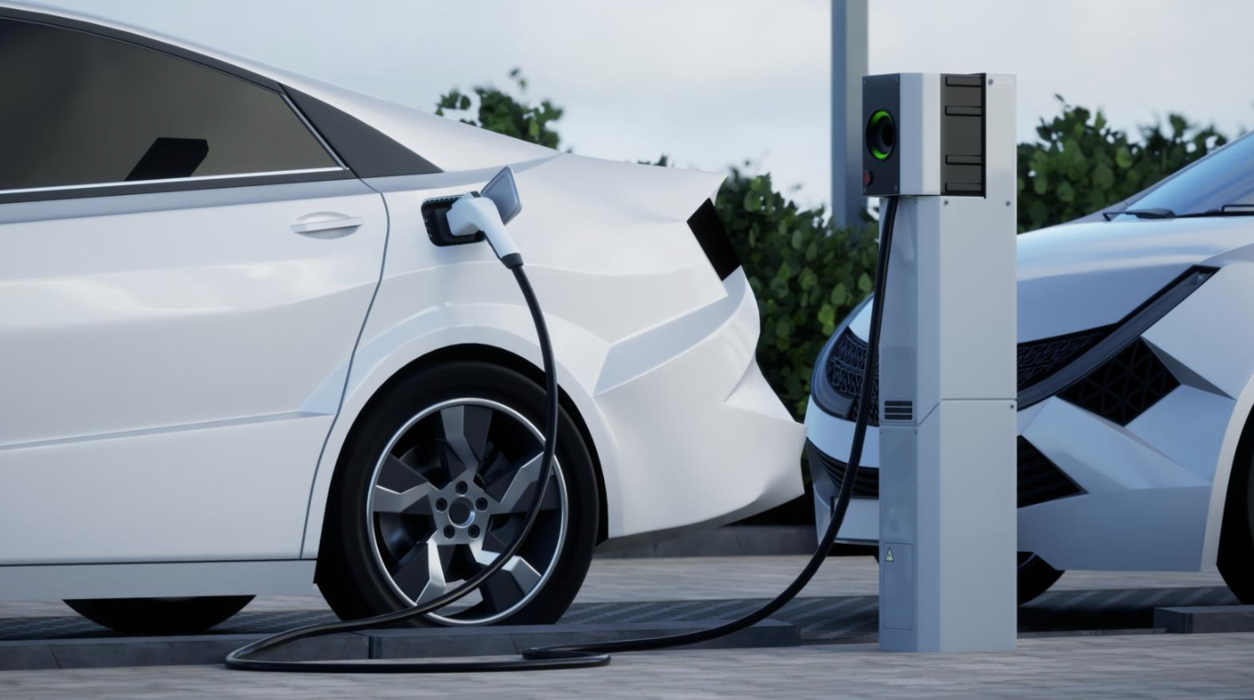 Generic electric car charging on a city street. This image doesn’t contain any visible trademarked products, corporate identity, logos, or copyrighted elements.