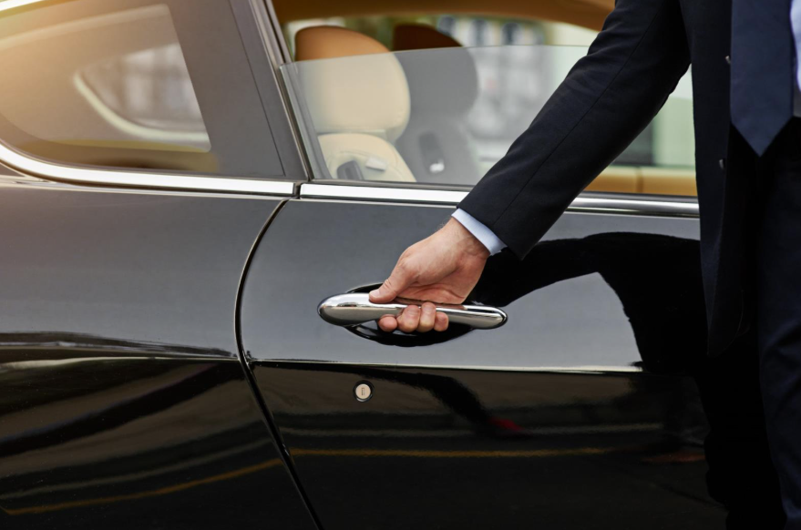 Cropped shot of an unrecognisable male chauffeur opening a car door