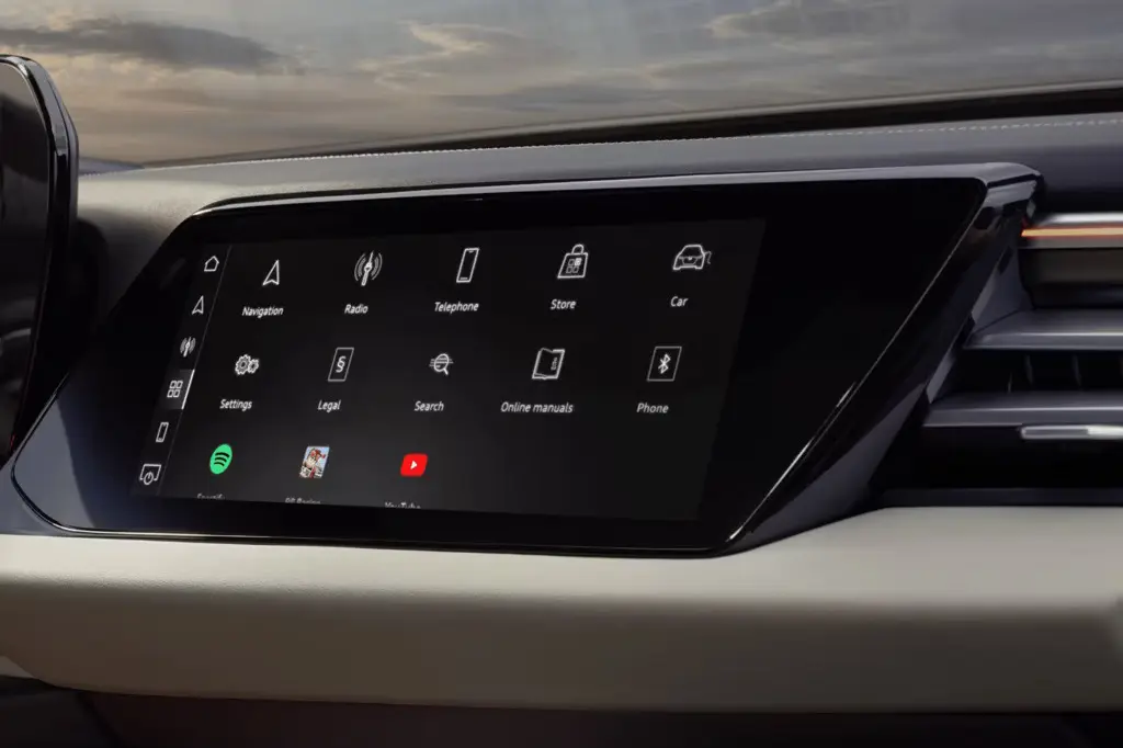Close-up of Audi A5 touchscreen infotainment system with Spotify, YouTube, and vehicle settings apps