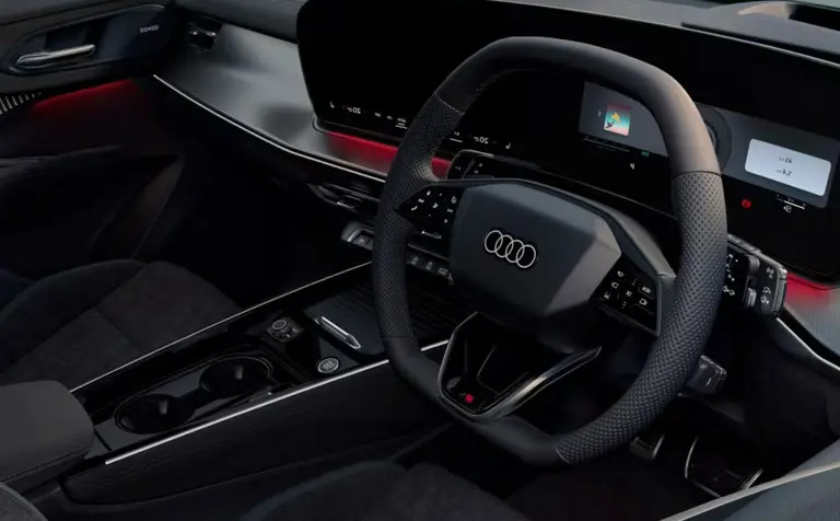 Modern Audi Q3 interior featuring ambient red lighting, digital displays, and black leather seats