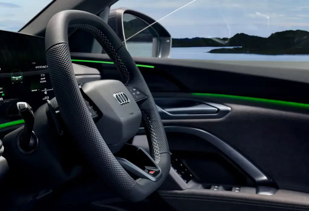 Close-up of an Audi Q5 steering wheel and driver‘s side with an ocean background through the window.