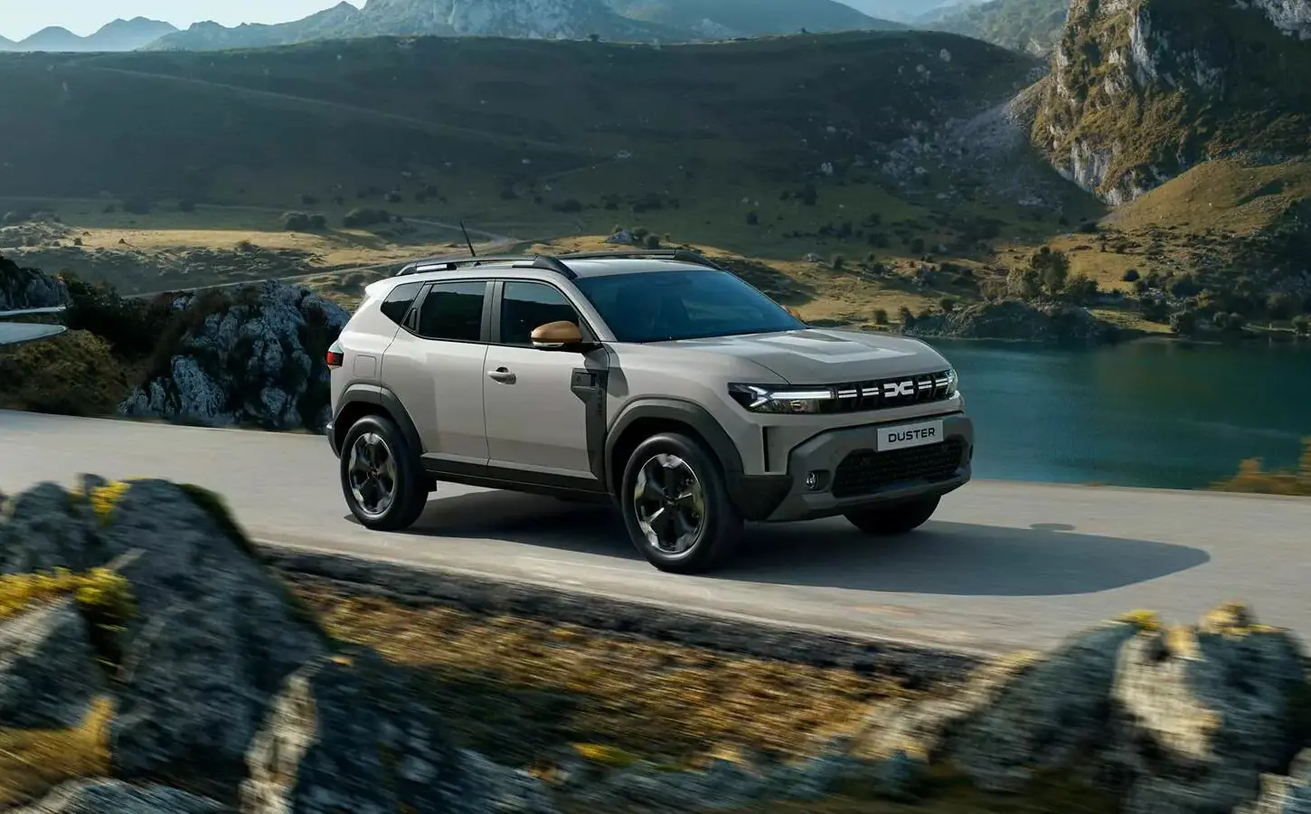 A grey Dacia Duster being driven along a mountainous rural road