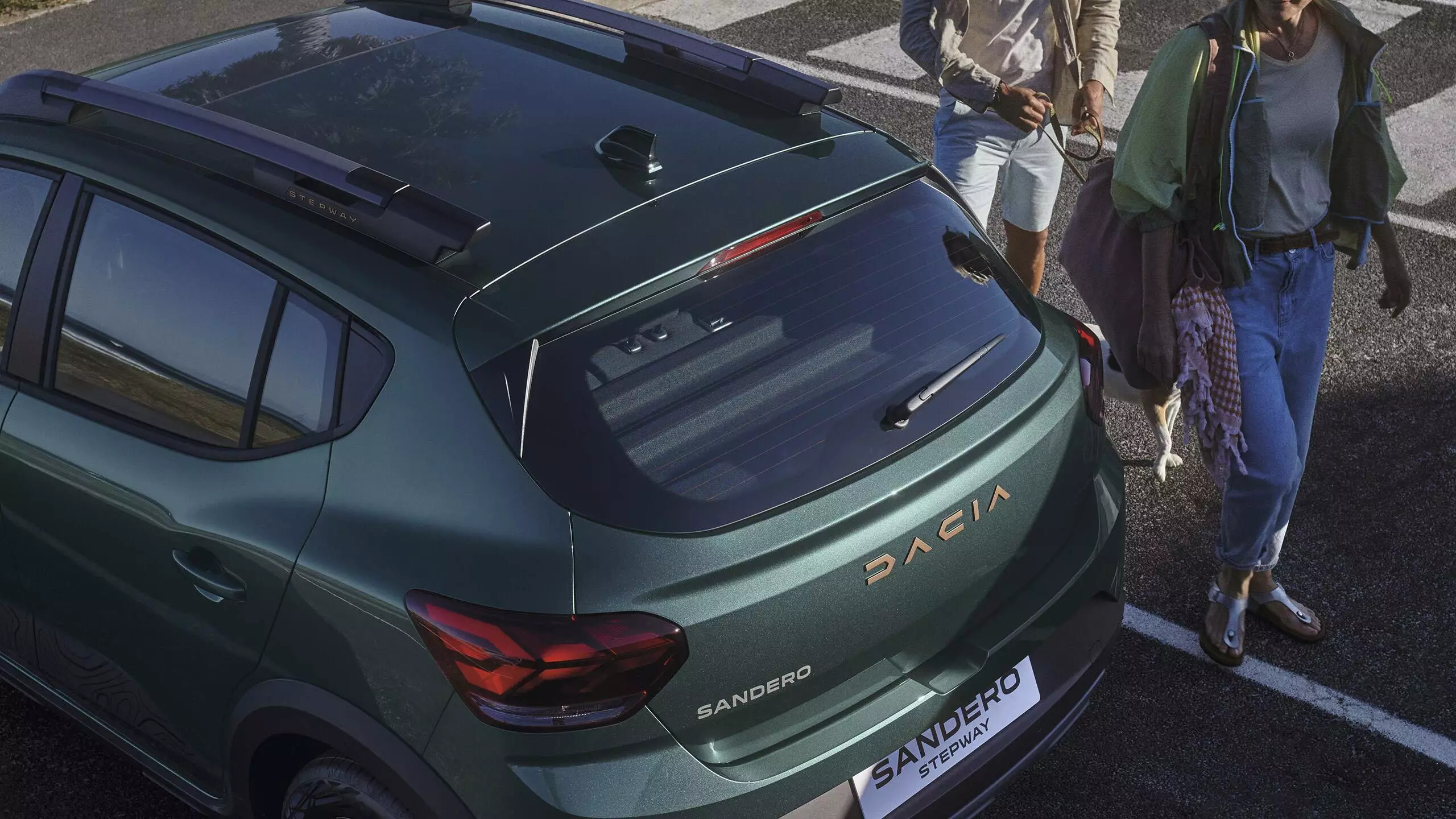 A close up shot of the back of a green Dacia Sandero Stepway car parked in a car park