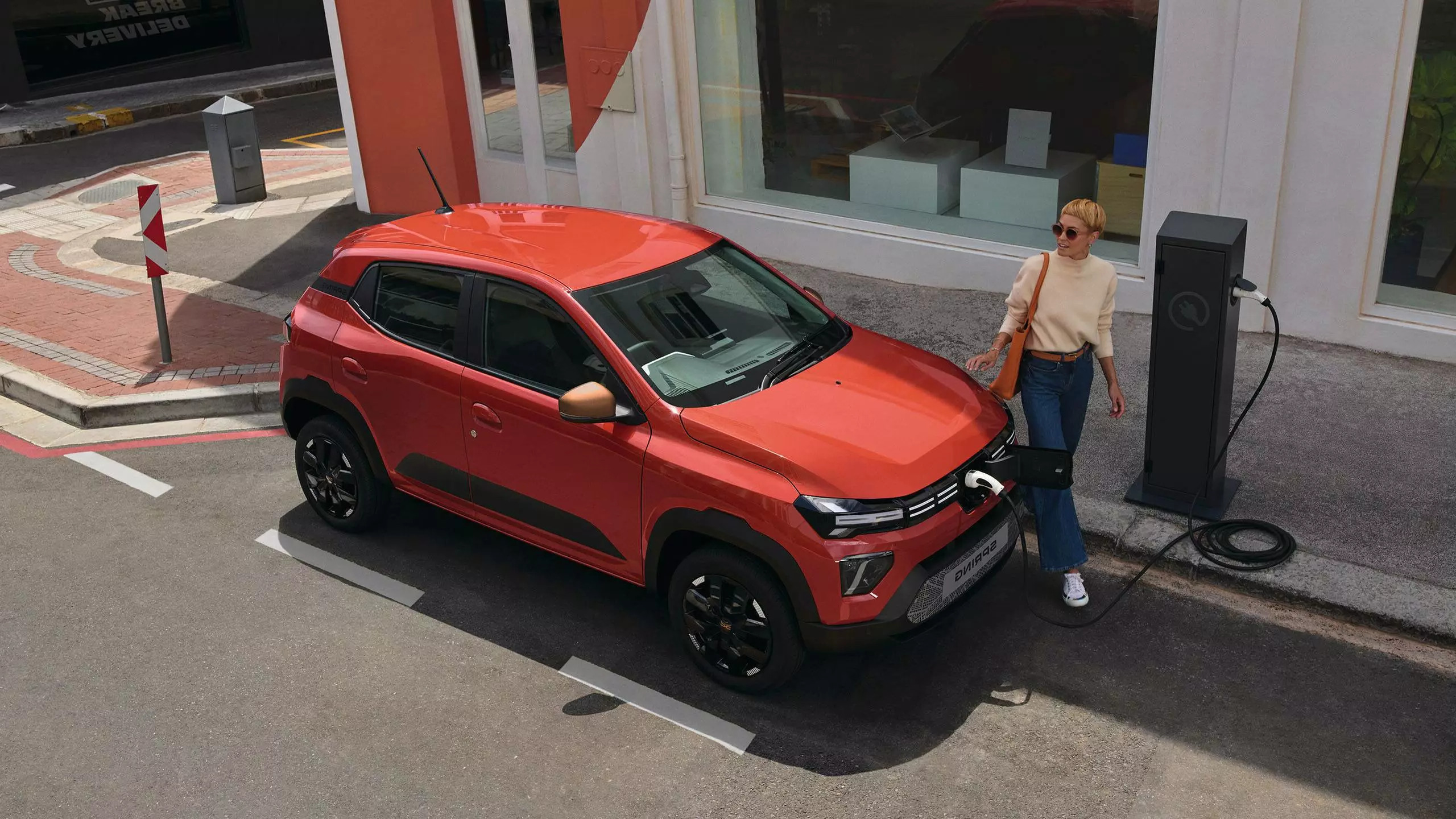 A woman charging her electric car on the city street
