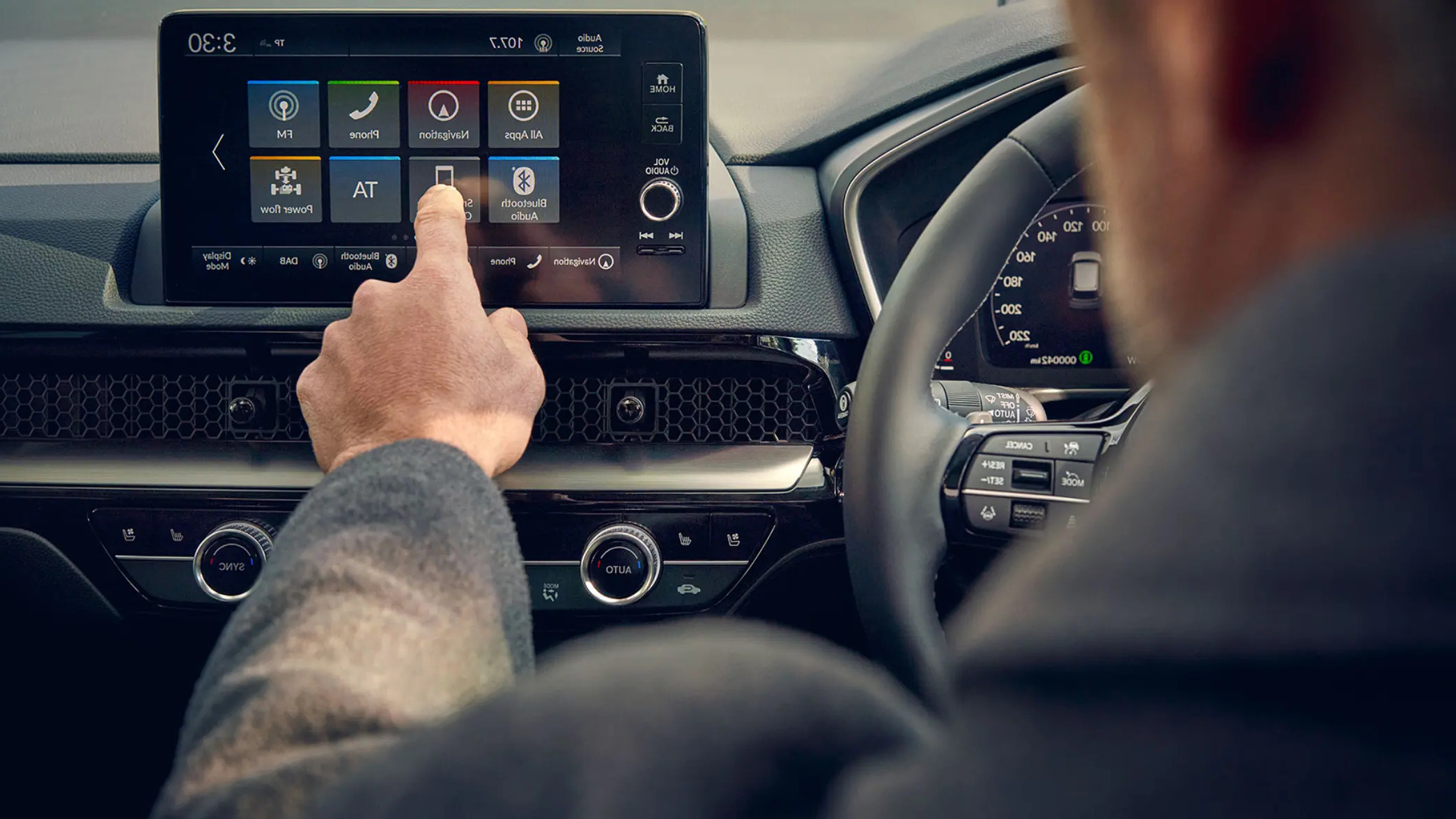 A man using the navigation system in a Honda Civic car