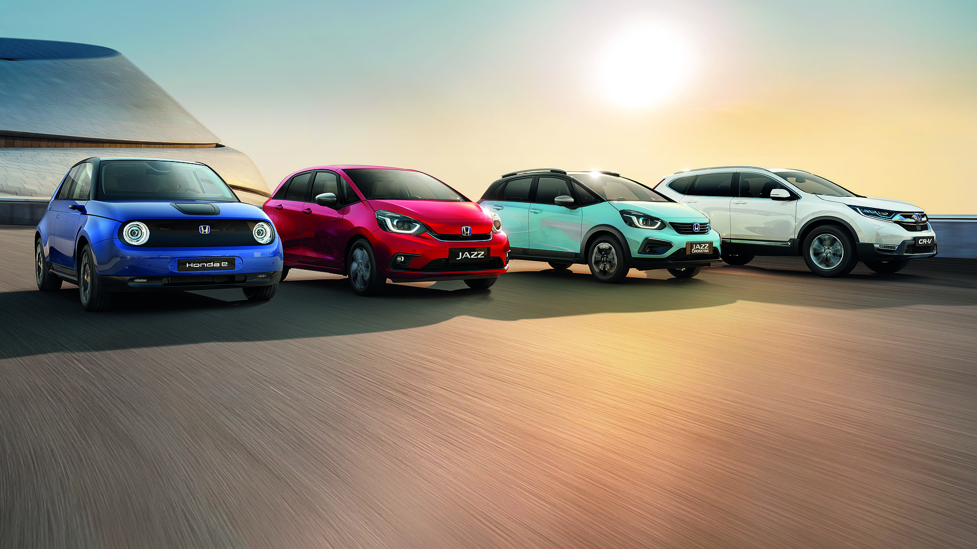 Showcasing the range of Honda cars in different colours parked in a line next to each other.