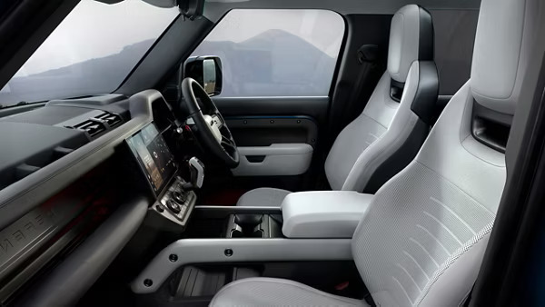 A sleek, modern grey interior of a Land Rover Defender with a touch display screen