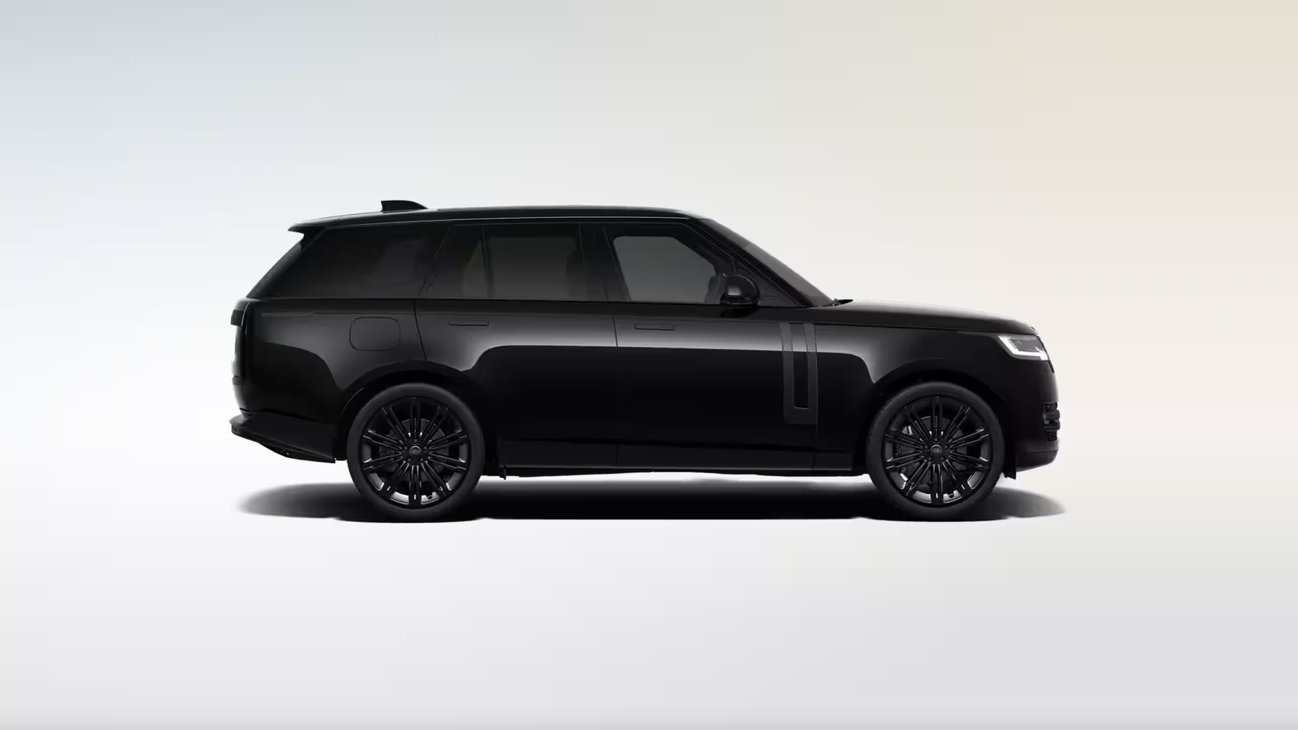 A side view of a black Land Rover Range Rover vehicle on a white background