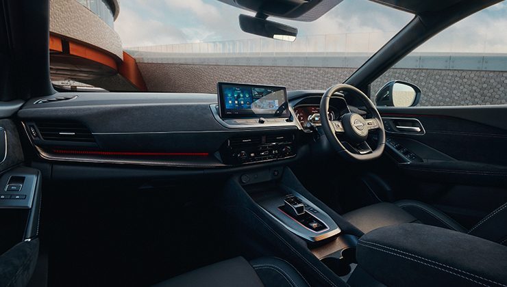 Interior view of a Nissan Qashqai car with the steering wheel and infotainment system