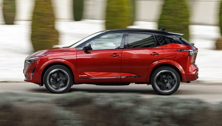 man driving a red Nissan Qashqai on the road