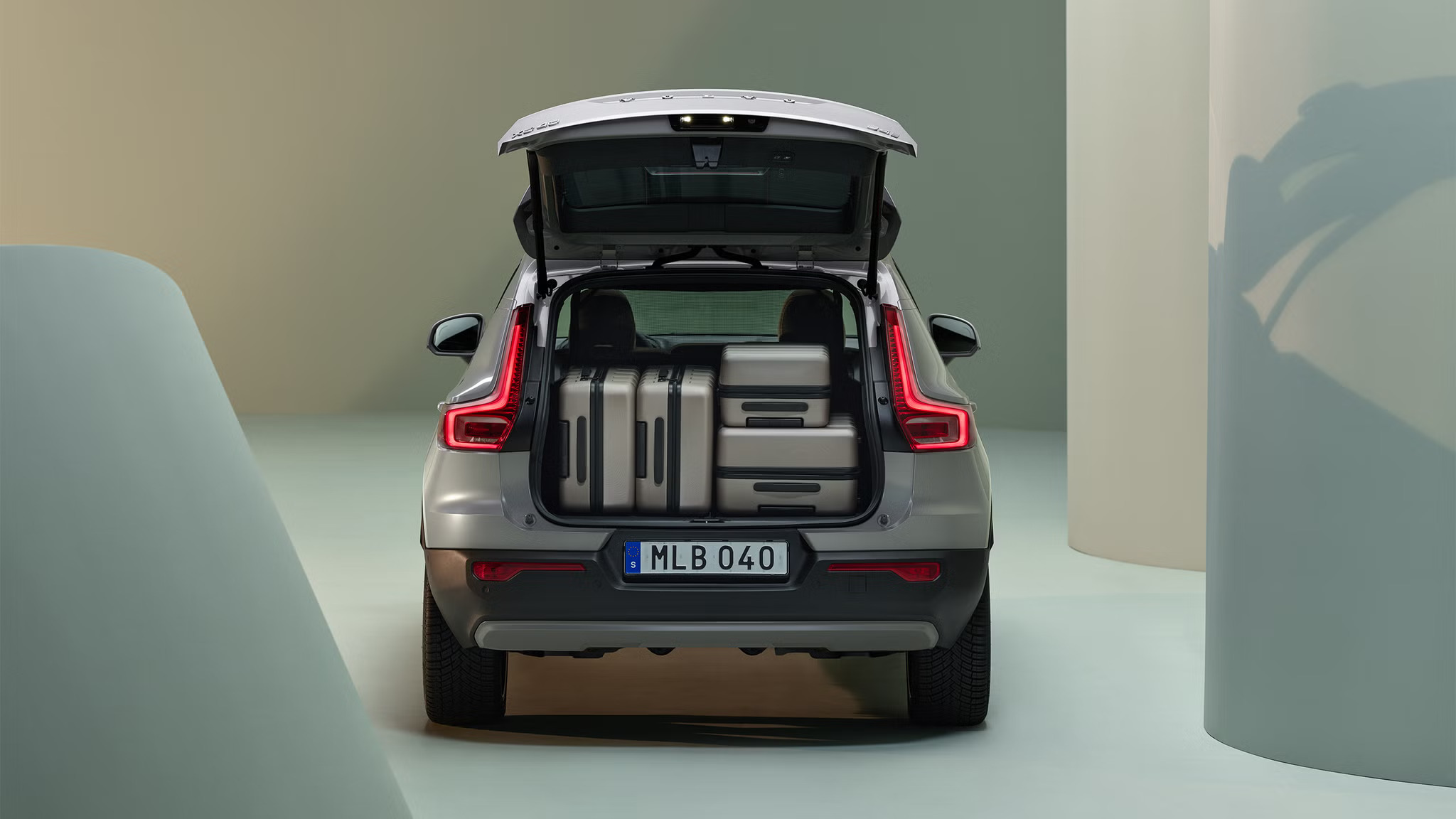 The inside of a silver Volvo XC40 car boot with a stack of suitcases