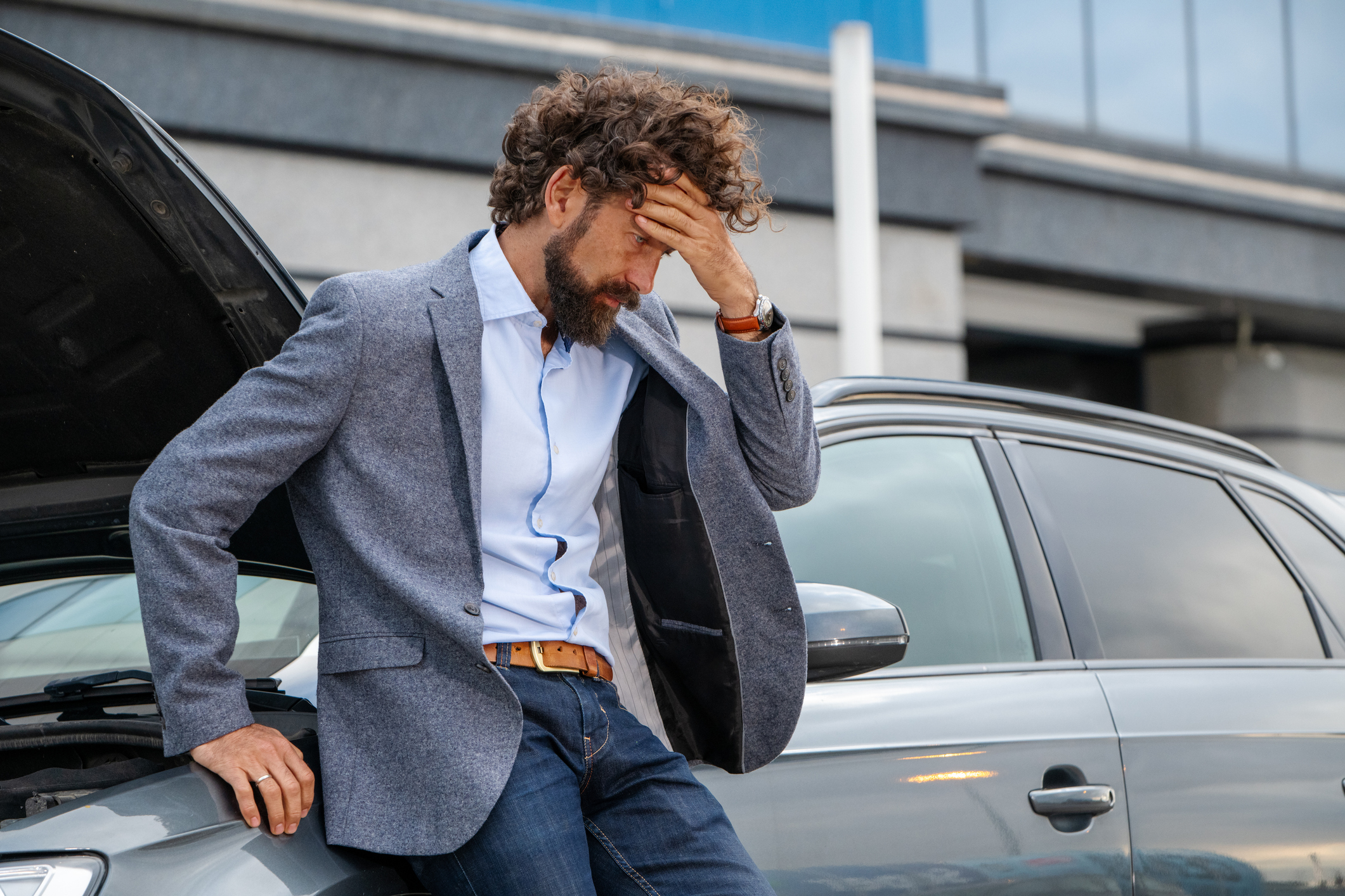 Everyday commuter or businessman caught mid-crisis reacting to mechanical failure with visible stress. Great for auto repair services, warranty programs, or mobile mechanic app visuals. Authentic emotion, clean composition. 