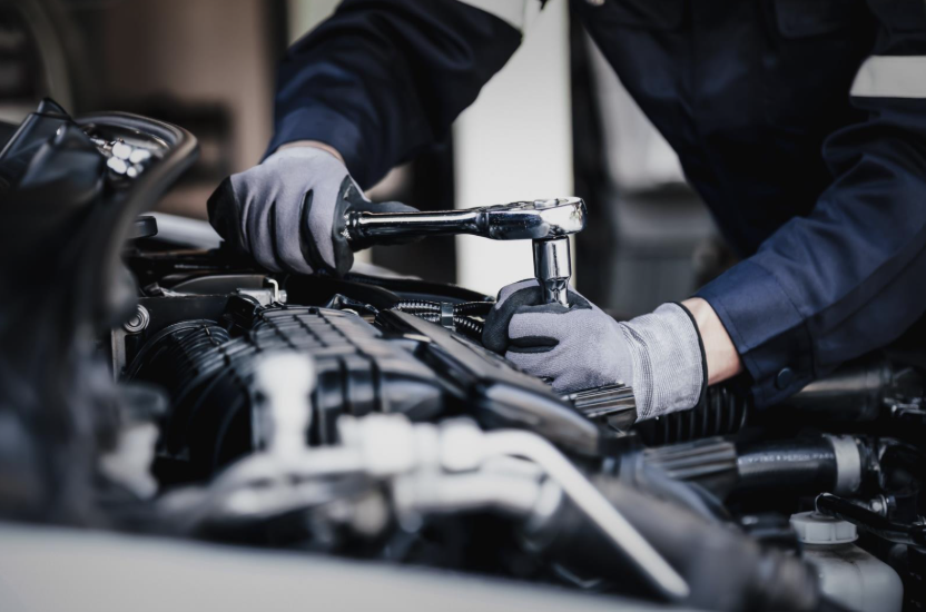 Professional mechanic working on the engine of the car in the garage. Car repair service. The concept of checking the readiness of the car before leaving. 
