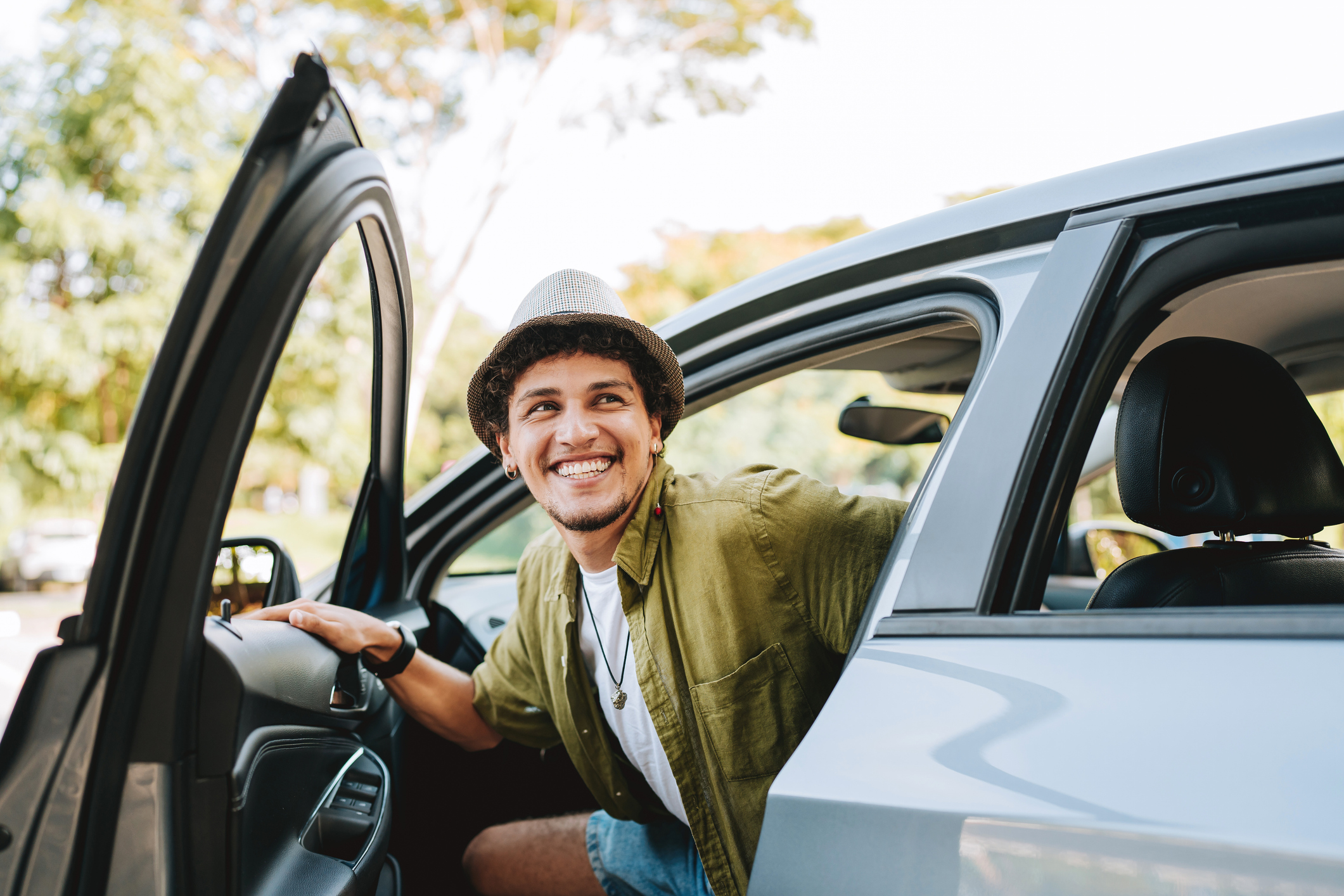 Young man traveling by car getting out of the car. 